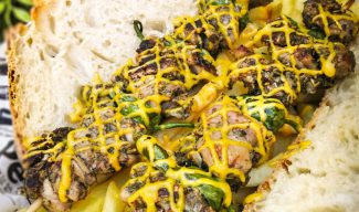 Brocheta de lechazo con pimientos de Padrón acompañado de una salsa de mostaza y miel